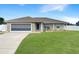 Charming single-story home features a well-maintained lawn, neutral exterior, and a driveway leading to the garage at 6011 Country Walk Ln, Winter Haven, FL 33880