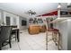 Bright living room featuring tile flooring, a ceiling fan, a bar counter with seating, and comfortable leather chairs at 6011 Country Walk Ln, Winter Haven, FL 33880