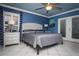 Stylish primary bedroom with blue walls, tiled floors, ceiling fan, and access to an outdoor area at 6011 Country Walk Ln, Winter Haven, FL 33880