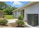 Exterior view of the side of the house with an AC unit and small yard with grass and bushes at 608 Swanson St, Groveland, FL 34736