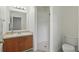 Cozy bathroom with modern lighting, vanity with wood cabinets, and a walk-in shower with white tiles at 608 Swanson St, Groveland, FL 34736
