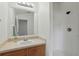 Inviting bathroom with modern lighting, vanity with wood cabinets, and a walk-in shower with white tiles at 608 Swanson St, Groveland, FL 34736