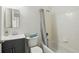 Well-lit bathroom with a sleek vanity, toilet, and tiled shower-tub combination with a shower curtain at 608 Swanson St, Groveland, FL 34736