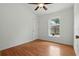 Bright bedroom featuring wood-look floors, white walls, ceiling fan, and a window allowing ample natural light at 608 Swanson St, Groveland, FL 34736