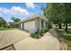View of the detached garage and driveway featuring a two-car garage, landscaping, and exterior paint at 608 Swanson St, Groveland, FL 34736