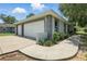 View of the detached garage and driveway featuring a two-car garage, landscaping, and exterior paint at 608 Swanson St, Groveland, FL 34736