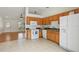 Bright kitchen featuring light-brown cabinetry, white appliances and seamlessly open to the living area at 608 Swanson St, Groveland, FL 34736