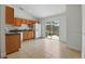 Bright kitchen featuring light-brown cabinetry, white appliances and sliding glass doors leading to the backyard at 608 Swanson St, Groveland, FL 34736