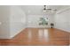Bright and airy living room with wood laminate floors, ceiling fan, and a front-facing window at 608 Swanson St, Groveland, FL 34736