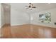 Bright and airy living room with wood laminate floors, ceiling fan, and a front-facing window at 608 Swanson St, Groveland, FL 34736