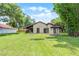 Spacious backyard with well-maintained lawn and views of the home's exterior featuring sliding glass doors at 6301 Parson Brown Dr, Orlando, FL 32819