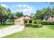 Charming single-story home with a well-manicured lawn, lush landscaping, and an attached garage, in a golf community at 6301 Parson Brown Dr, Orlando, FL 32819