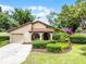 Charming single-story home featuring a red tile roof and a well-manicured front yard with lush landscaping at 6301 Parson Brown Dr, Orlando, FL 32819