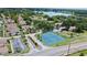 Community aerial view featuring tennis courts, lush greenery, and a serene lake backdrop at 750 Olympic Cir # D1, Ocoee, FL 34761