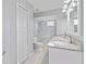 Bathroom featuring double sinks with granite countertops and tiled shower with glass block window at 750 Olympic Cir # D1, Ocoee, FL 34761