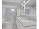 Bathroom featuring double sinks, granite countertops, and tiled shower with a glass block window at 750 Olympic Cir # D1, Ocoee, FL 34761