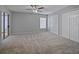 Spacious bedroom with neutral carpet, ceiling fan, and double closets at 750 Olympic Cir # D1, Ocoee, FL 34761