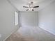 Bright bedroom features neutral carpeting, paint, and a ceiling fan at 750 Olympic Cir # D1, Ocoee, FL 34761