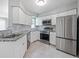 Modern kitchen featuring stainless steel appliances, granite countertops, and white cabinets at 750 Olympic Cir # D1, Ocoee, FL 34761