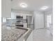 Well-lit kitchen featuring stainless steel appliances, white cabinetry, and granite countertops at 750 Olympic Cir # D1, Ocoee, FL 34761