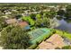 An aerial view featuring a basketball court with lush green landscape, a pond, and surrounding residential homes at 901 Grovesmere Loop, Ocoee, FL 34761