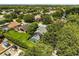 An aerial view of the home showing a lush green lawn, a screened-in pool, and mature trees in the neighborhood at 901 Grovesmere Loop, Ocoee, FL 34761