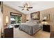 Comfortable bedroom with ceiling fan, neutral paint, and natural light from the window at 901 Grovesmere Loop, Ocoee, FL 34761