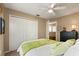 Relaxing bedroom with neutral walls, a ceiling fan, bright throw pillows and a view to closet at 901 Grovesmere Loop, Ocoee, FL 34761