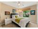 Light bedroom with a ceiling fan, a black headboard, bright accents, and a window view at 901 Grovesmere Loop, Ocoee, FL 34761