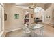 Open-concept dining room featuring glass table, neutral carpeting, and is open to the kitchen and living spaces at 901 Grovesmere Loop, Ocoee, FL 34761