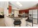 Kitchen features modern stainless steel appliances, sleek countertops, tile backsplash, and a built-in breakfast bar at 901 Grovesmere Loop, Ocoee, FL 34761