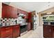 Modern kitchen with stainless steel appliances, cherry wood cabinets, and tiled backsplash at 901 Grovesmere Loop, Ocoee, FL 34761
