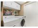 Well-equipped laundry room with modern white washer and dryer units, and overhead storage cabinets at 901 Grovesmere Loop, Ocoee, FL 34761