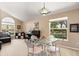 Bright living room features large windows, comfortable seating, and a piano with a serene view of the outdoors at 901 Grovesmere Loop, Ocoee, FL 34761