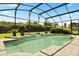 A refreshing pool featuring a waterfall feature surrounded by a screened enclosure and well-manicured landscaping at 901 Grovesmere Loop, Ocoee, FL 34761