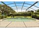 Screened-in pool showcasing a charming waterfall feature, surrounded by lush greenery and a tiled deck at 901 Grovesmere Loop, Ocoee, FL 34761
