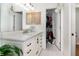 Bathroom featuring a large vanity with a white countertop, drawers, and a door to a walk-in closet at 9355 Telfer Run, Orlando, FL 32817