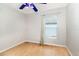 Vacant bedroom showcasing a window with blinds, light-colored walls, and hardwood floors at 9355 Telfer Run, Orlando, FL 32817