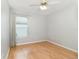 Well-lit, empty bedroom with a large window, neutral paint, and hardwood floors at 9355 Telfer Run, Orlando, FL 32817