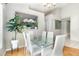 Elegant dining room with a glass table, white chairs, and views into the kitchen area at 9355 Telfer Run, Orlando, FL 32817