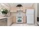 Functional kitchen with white appliances, light-colored cabinets, and tile flooring at 9355 Telfer Run, Orlando, FL 32817