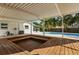 Wooden deck includes a sunken hot tub or seating area in a backyard with tropical landscaping and a pool in the background at 955 Tomes Ct, Orlando, FL 32825