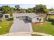 Shows a modern house with gray driveway and walkway, well-manicured lawn, and a combination of siding and stonework at 955 Tomes Ct, Orlando, FL 32825