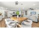 Bright, open-concept living room with modern furnishings and a wood dining table at 955 Tomes Ct, Orlando, FL 32825