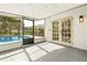 View of the outdoor patio that leads to the pool, with neutral tile flooring and traditional-style paneled doors at 955 Tomes Ct, Orlando, FL 32825