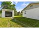 Shows a well-maintained yard with green grass, an exterior storage unit, and the side of the house at 955 Tomes Ct, Orlando, FL 32825