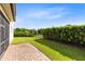 This backyard features a well-maintained lawn, a brick patio, and a manicured hedge at 9978 Mere Pkwy, Orlando, FL 32832