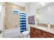 This well-lit bathroom features a shower-tub combo and vanity with granite countertops and ample storage at 9978 Mere Pkwy, Orlando, FL 32832