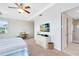 Bedroom featuring a large window, tray ceiling, and access to the Primary bathroom at 9978 Mere Pkwy, Orlando, FL 32832