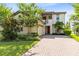 Elegant two-story home featuring a brick driveway, manicured landscaping, and a welcoming entrance at 9978 Mere Pkwy, Orlando, FL 32832